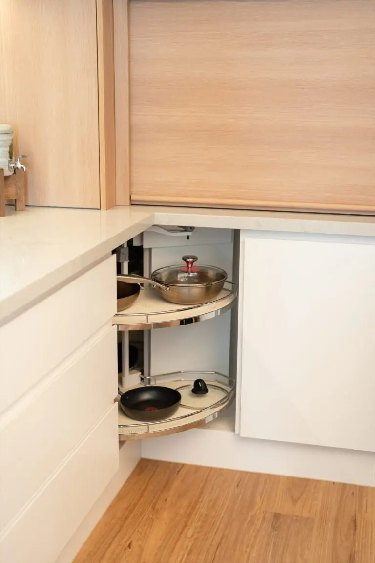 A corner carousel unit pulled out from a warm oak kitchen