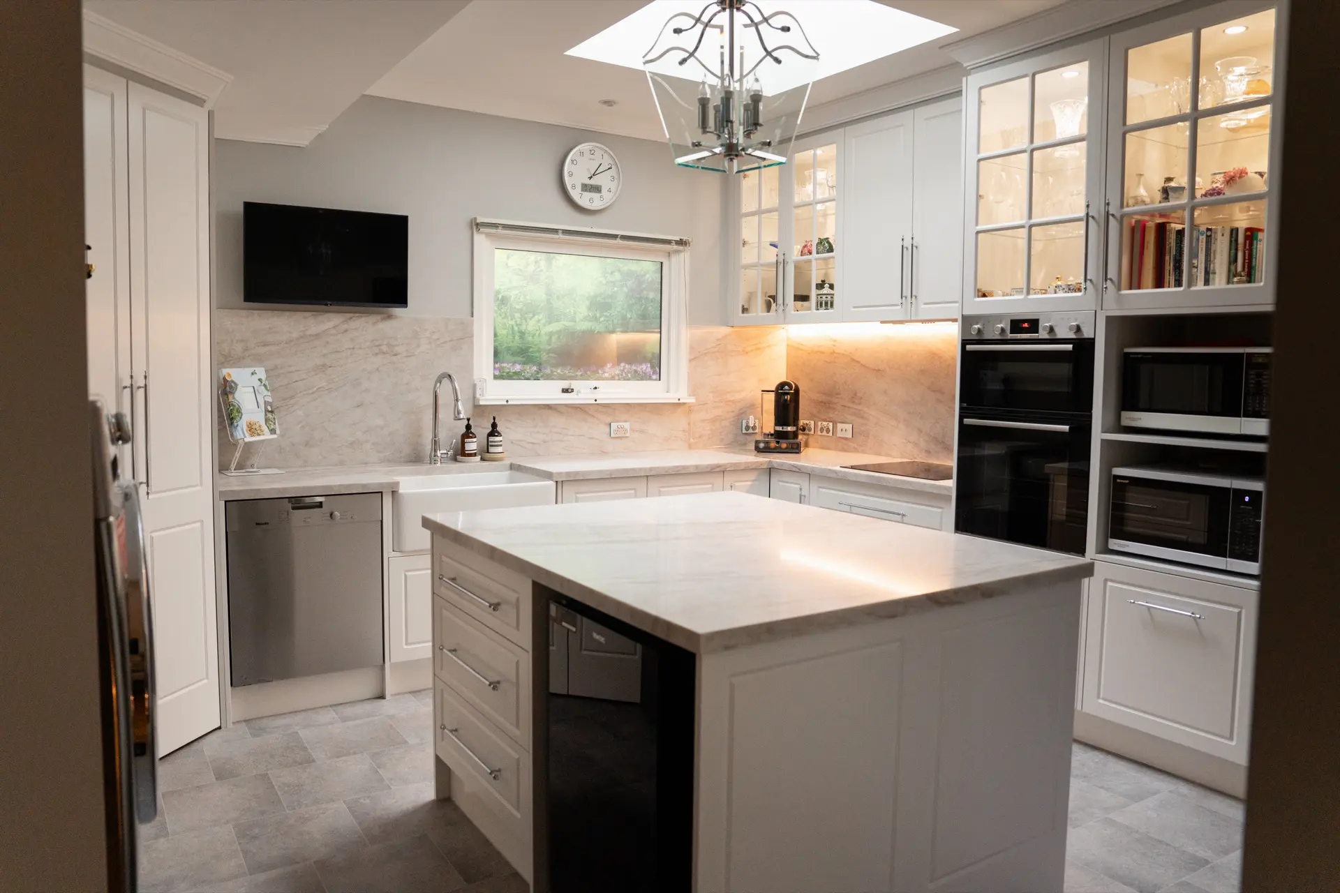 A classic cream shaker kitchen with a marble island and pendant lighting